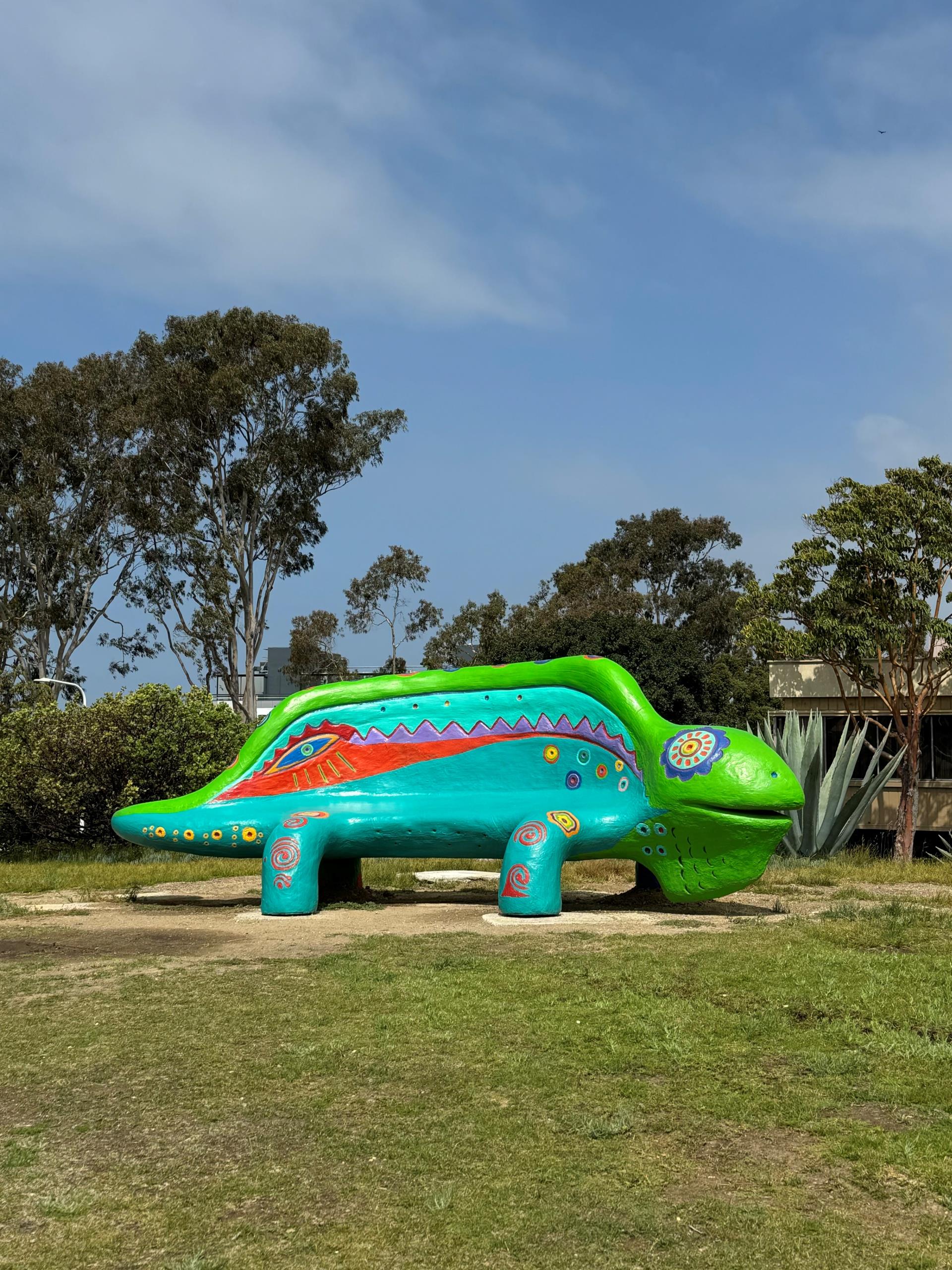 A colorful bench shaped like a gecko - sculpture in Civic Center Park